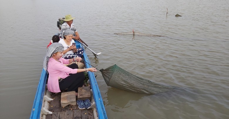 Gia đình nhiều thế hệ chụp ảnh tại cột mốc Tam Giác Vàng bên sông Mekong