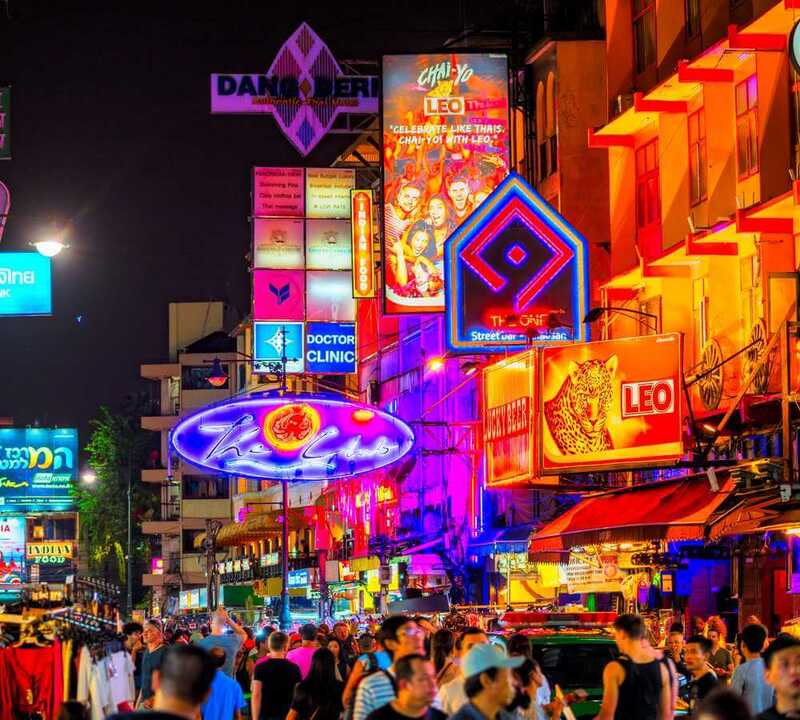 Toàn cảnh phố Khao San Road buổi tối với đèn neon và biển hiệu quán bar