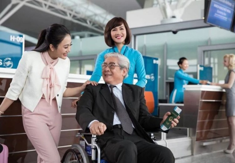 Nhân viên sân bay hỗ trợ hành khách lớn tuổi bằng xe lăn